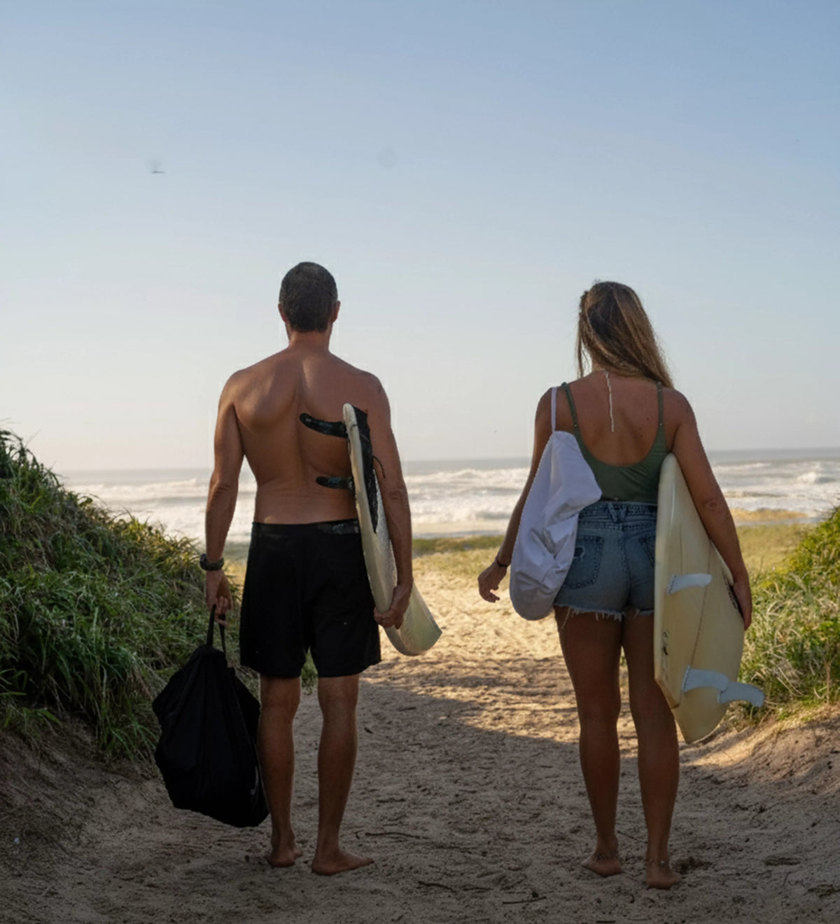 Couple walking to the surf with Latina Beach gear